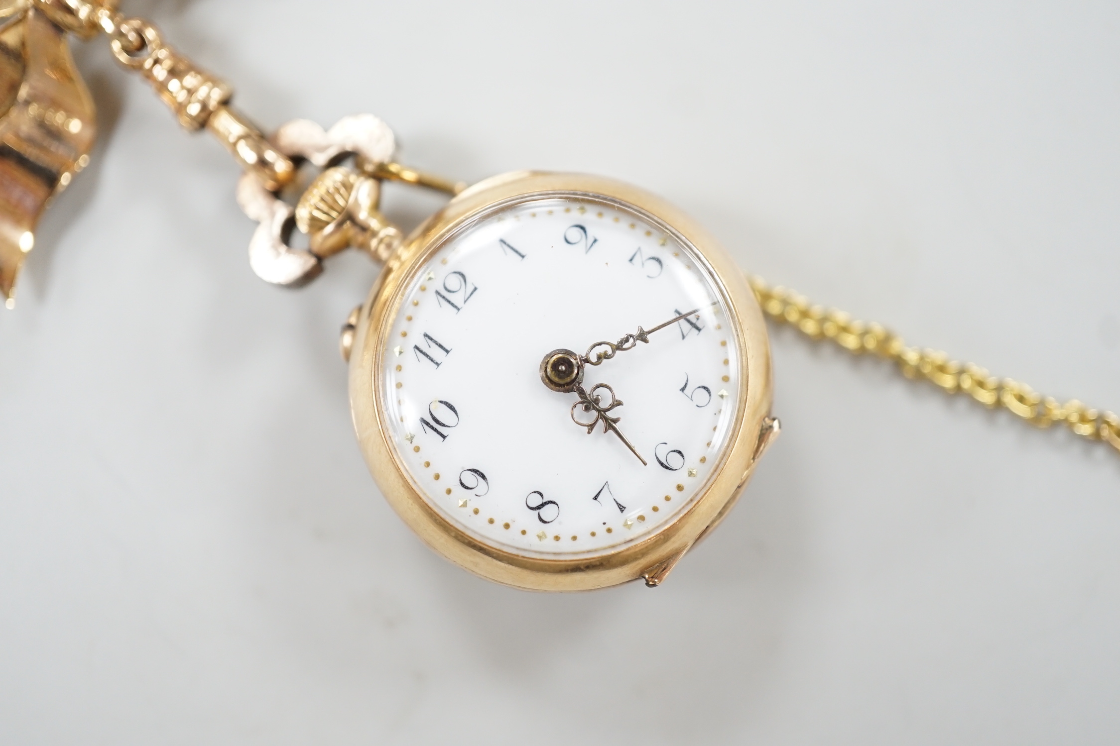 A lady's late 19th century French? yellow metal, emerald and rose cut diamond cluster set fob watch, diameter 24mm, suspended from a late Victorian 9ct gold ribbon bow brooch, gross weight 17.1 grams.